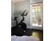 Peloton bike with desk in bright home gym, hardwood floors, and view to backyard at 120 Howard Se St, Atlanta, GA 30317