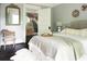 Cozy main bedroom featuring a decorative mirror, a comfortable chair, and a view of the ensuite bathroom at 120 Howard Se St, Atlanta, GA 30317