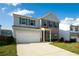 Charming two-story home with brick accents, light blue siding, lush lawn, and two car garage at 816 Royal Red Ct, Mcdonough, GA 30253