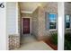 Close up of the front door with brick accents, gray shutters, and lush green bushes at 816 Royal Red Ct, Mcdonough, GA 30253