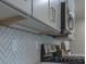 Under-cabinet lighting above kitchen counter with herringbone backsplash at 704 Fairgate Rd, Marietta, GA 30064