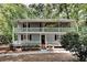 Charming home featuring a classic two-story design with dual-level balconies and a surrounding wooded landscape at 3337 Devaughn Ne Dr, Marietta, GA 30066