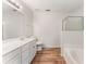 Bathroom featuring a double sink vanity, tile floor, and soaking tub at 5845 Hampton Ct, Atlanta, GA 30349