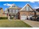 Two-story house with a brick facade, two-car garage, and landscaped lawn at 169 Blue Creek Ln, Loganville, GA 30052