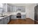 Modern kitchen with gray cabinets, quartz countertops, and stainless steel appliances at 169 Blue Creek Ln, Loganville, GA 30052