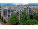 Modern apartment building with brick and stone accents, surrounded by lush green trees at 390 17Th Nw St # 4063, Atlanta, GA 30363