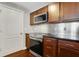 View of the kitchen featuring stainless steel oven, cooktop, and dark wood cabinetry at 390 17Th Nw St # 4063, Atlanta, GA 30363