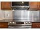 Close-up of stainless steel oven and cooktop with dark countertop and cabinets at 390 17Th Nw St # 4063, Atlanta, GA 30363