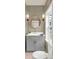 Stylish powder room featuring a gray vanity and a round mirror at 702 Fairgate Rd, Marietta, GA 30064