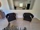 Two black accent chairs with gold legs in front of kitchen passthrough at 208 Willows Ct, Riverdale, GA 30274