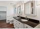 Modern bathroom featuring double vanity with black countertop and wood-look flooring at 2423 Cedar Wood Ct, Marietta, GA 30068