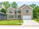 Two-story brick home with a white garage door and landscaped lawn at 5649 Eagles Watch, Douglasville, GA 30135