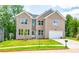Two story brick home with a white garage door and landscaped lawn at 5649 Eagles Watch, Douglasville, GA 30135