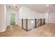 Upstairs hallway with light hardwood floors and railing at 5649 Eagles Watch, Douglasville, GA 30135