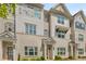 Beige brick townhome with gray shutters, white columns, and landscaping at 1708 Evenstad Way, Smyrna, GA 30080