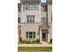 Beige brick townhome with gray shutters, white columns, and landscaping at 1708 Evenstad Way, Smyrna, GA 30080