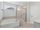 Bathroom featuring a soaking tub, glass-enclosed shower, and neutral tile at 313 Foxglove Way, Mcdonough, GA 30253