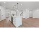 Bright open concept kitchen showcasing stainless steel appliances, a kitchen island, and wood flooring at 313 Foxglove Way, Mcdonough, GA 30253