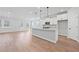 A bright kitchen with white cabinets, a large island with pendant lighting, and stainless steel appliances at 313 Foxglove Way, Mcdonough, GA 30253