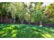 Landscaped backyard with lush lawn and brick wall at 9680 Almaviva Dr, Alpharetta, GA 30022