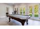 Basement recreation area includes a pool table and plenty of natural light from the French doors at 9680 Almaviva Dr, Alpharetta, GA 30022