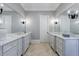 Double vanity bathroom with marble countertops and gray cabinets at 9680 Almaviva Dr, Alpharetta, GA 30022