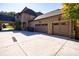 Three-car garage with a large driveway and brick house at 9680 Almaviva Dr, Alpharetta, GA 30022