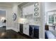 Stylish wet bar with white cabinetry, marble backsplash, and wine cooler at 9680 Almaviva Dr, Alpharetta, GA 30022