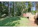 Lush backyard with a deck, red shed, and beautiful greenery and mature trees at 1931 Oana Sw St, Atlanta, GA 30310