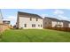 Large backyard with lush green grass is surrounded by a wood fence and other neighboring homes at 236 Begonia Way, Mcdonough, GA 30253