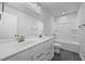 Bright bathroom features a double sink vanity, tub with tile surround and modern fixtures at 236 Begonia Way, Mcdonough, GA 30253
