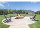 Outdoor fire pit with Adirondack chairs, landscaping, and green space at 236 Begonia Way, Mcdonough, GA 30253