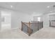 Hallway features wood and black railings, and neutral walls and carpet at 236 Begonia Way, Mcdonough, GA 30253
