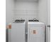 Convenient laundry room features modern washer and dryer with a wire rack above for storage at 236 Begonia Way, Mcdonough, GA 30253