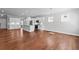 Open-concept living area with hardwood floors, white walls, and an open kitchen with modern appliances at 236 Begonia Way, Mcdonough, GA 30253