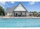 Community pool with lounge chairs and a covered seating area next to a neighboring residential home at 236 Begonia Way, Mcdonough, GA 30253