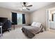 Bedroom features neutral walls, ceiling fan, window, carpet, and a view to the ensuite bathroom at 5669 Hollowbrooke Nw Ln, Acworth, GA 30101