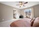 Cozy bedroom with a ceiling fan, window, and adjoining bathroom at 5669 Hollowbrooke Nw Ln, Acworth, GA 30101