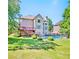 Lovely backyard view of a two-story home with deck and pool surrounded by a fenced-in green lawn at 5669 Hollowbrooke Nw Ln, Acworth, GA 30101