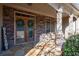 Charming front porch featuring a stone facade, seating area and decorated with wreaths on the glass doors at 5669 Hollowbrooke Nw Ln, Acworth, GA 30101