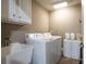 Functional laundry room with sink, storage cabinets, washer, and dryer with neutral paint at 5669 Hollowbrooke Nw Ln, Acworth, GA 30101