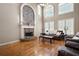 Bright living room featuring a stone fireplace, hardwood floors, and large windows at 5669 Hollowbrooke Nw Ln, Acworth, GA 30101