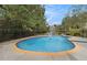 Relaxing swimming pool with fountain and tan brick border encircled by a dark metal fence and verdant greenery at 5669 Hollowbrooke Nw Ln, Acworth, GA 30101