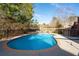 Inviting backyard pool featuring a fountain, brick trim, dark metal fence, and the serenity of a backyard at 5669 Hollowbrooke Nw Ln, Acworth, GA 30101