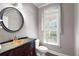 Charming powder room features pedestal sink, decorative mirror, and natural light at 5669 Hollowbrooke Nw Ln, Acworth, GA 30101