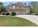 View of the three-car garage with long driveway and well-kept lawn at 5669 Hollowbrooke Nw Ln, Acworth, GA 30101