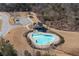 Aerial view of a community pool with an irregular shape and pool house, surrounded by trees at 4770 Alford Commons, Cumming, GA 30028