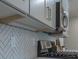 Close-up of kitchen cabinets, herringbone backsplash, and under-cabinet lighting at 712 Fairgate Rd, Marietta, GA 30064