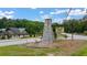 Milam Park community entrance sign with stone pillar and landscaping in a wooded area at 907 E Green Ln, Clarkston, GA 30021
