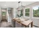 Bright dining area features wood table, modern chandelier, and large windows at 907 E Green Ln, Clarkston, GA 30021